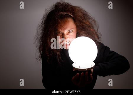 Fortuneteller che le tiene le mani una palla incandescente. Foto Stock