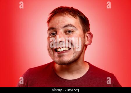 Uomo sorridente su sfondo rosso. Foto Stock