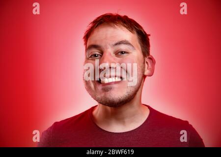 Uomo sorridente su sfondo rosso. Foto Stock