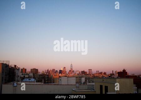 Il sole che sorge su Manhattan, New York City, visto da un tetto a Brooklyn. Foto Stock