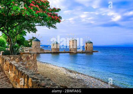 Autentico scenario tradizionale greco - vecchi mulini a vento vicino al mare - punto di riferimento dell'isola di Chios Foto Stock