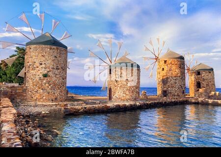 Autentico scenario tradizionale greco - vecchi mulini a vento vicino al mare - punto di riferimento dell'isola di Chios Foto Stock