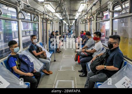 Manila, Filippine. 1 Giugno 2020. Le persone che indossano maschere di protezione osservano le distanze sociali mentre cavalcano un treno il primo giorno in cui le restrizioni di blocco COVID-19 sono state ulteriormente attenuate a Manila, nelle Filippine, il 1 giugno 2020. Il presidente filippino Rodrigo Duterte il 28 maggio ha annunciato di allentare ulteriormente le restrizioni di blocco in Metro Manila dal 1 giugno per consentire a più imprese e trasporti di riaprire. Credit: Rouelle Umali/Xinhua/Alamy Live News Foto Stock