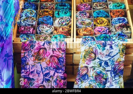 molti foulards arrotolati in casse di legno di una bancarella di mercato Foto Stock