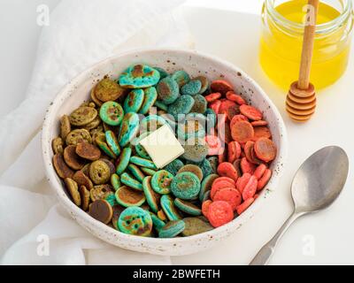 Cibo alla moda - cereali pancake. Un mucchio di mini frittelle di cereali colorate. Minuscoli pancake di colore naturale: Matcha verde, spirulina turchese, piselli blu, frutti rossi Foto Stock