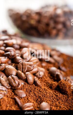 Caffè Beans e terreni primo piano. Sfondo. Chicchi di caffè in un recipiente di vetro sullo sfondo. Foto Stock