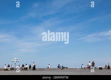 La gente si rilassa sulla terrazza del Kursaal a San Sebastian sotto un grande cielo blu Foto Stock