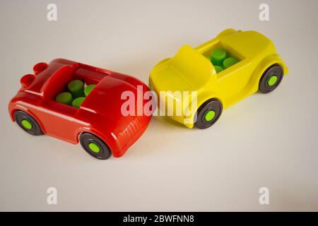 Macchinine giocattolo coinvolte in incidente, immagine concettuale con miniature e figurine su sfondo bianco. Primo piano di una collisione di due auto giocattolo su una bianca Foto Stock