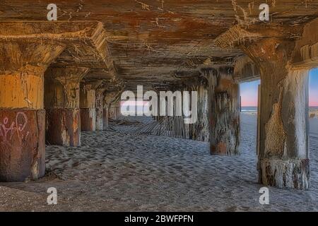 Asbury Park Pilings - una vista da sotto la Sala Congressi di Asbury Park con le palazzine in acciaio racchiusi nella spiaggia di Asbury Park nel New Jersey. Foto Stock