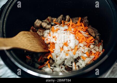 Le cipolle con le carote vengono fritte. Cucina casalinga. Vista dall'alto. Colori. Foto Stock