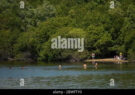 Londra, Regno Unito. 1 giugno 2020. UK Weather - persone in acqua al Ruislip Lido nel nord-ovest di Londra. Hillingdon Council ha chiuso la spiaggia al pubblico dopo diversi giorni in cui il pubblico non aderiva alle distanze sociali, poiché le restrizioni di blocco pandemiche del coronavirus sono state attenuate dal governo britannico. I cartelli presenti sul luogo indicano alle persone di non entrare nell'acqua poiché contiene pericoli potenzialmente dannosi per la salute umana. Credit: Stephen Chung / Alamy Live News Foto Stock