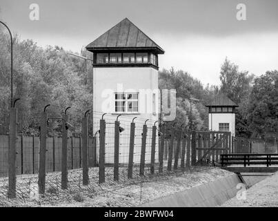 Recinzioni elettrificate a filo spinato e torre di guardia al campo di concentramento di Dachau. Fu il primo campo di concentramento nazista ed era un prototipo di f Foto Stock