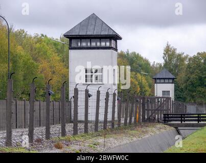 Recinzioni elettrificate a filo spinato e torre di guardia al campo di concentramento di Dachau. Fu il primo campo di concentramento nazista ed era un prototipo di f Foto Stock