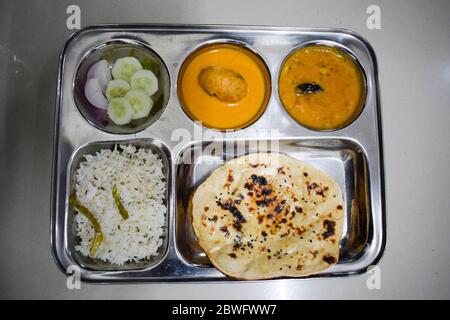 Thaali indiani vegetariani fatti in casa, costituiti da tandoori di grano burro roti, dal fry, riso di jera, insalata, kofta malai in lamiera di acciaio inox di duri Foto Stock