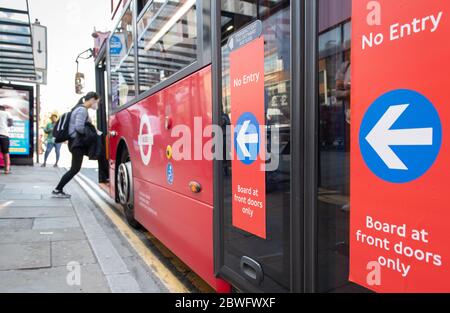 I nuovi adesivi sugli autobus ricordano ai pendolari la distanza sociale durante la pandemia COVID-19. Autobus a due piani, fermata dell'autobus, Lewisham. 30 maggio 2020. Foto Stock