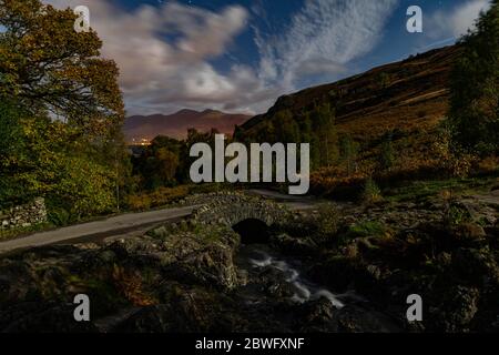 Ashness Bridge in una notte illuminata di luna guardando giù su Keswick Foto Stock