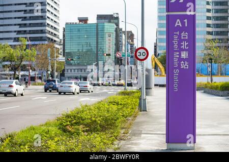 Cartello della stazione principale di Taipei in primo piano e traffico stradale sullo sfondo durante il coronavirus. Foto Stock