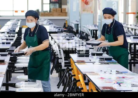 Pechino, Cina. 1 Giugno 2020. I membri del personale preparano il pranzo per gli studenti alla mensa della Tsinghua University High School di Pechino, capitale della Cina, il 1° giugno 2020. Gli studenti al primo e secondo grado di scuole superiori, al primo e al secondo grado di scuole superiori e al sesto grado di scuole elementari sono tornati a scuola per questo semestre a Pechino lunedì. Credit: Shen Bohan/Xinhua/Alamy Live News Foto Stock