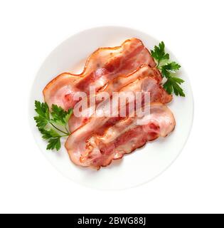 Fette di pancetta fritte su piastra isolata su sfondo bianco Foto Stock