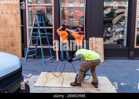 I carpentieri impiegati da EC Framing installano pannelli di legno in un bar a Soho, New York, il 1 giugno 2020 come misura precauzionale dopo che la violenza è scoppiata la domenica sera in relazione alle proteste di George Floyd, e i rioter hanno rotto le finestre del negozio e saccheggiato le imprese in SOHO. (Foto di Gabriele Holtermann/Sipa USA) Credit: Sipa USA/Alamy Live News Foto Stock