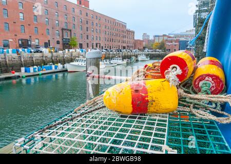 Boe a righe gialle e rosse o galleggianti su pentole di granchio sullo sfondo del porto di pesca e edifici industriali., Portland New England America. Foto Stock