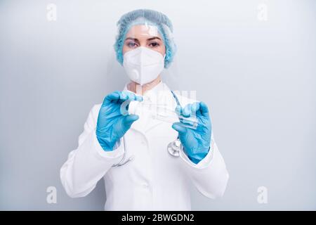 Foto di infermiera signora doc tenere provetta saliva raccogliere l'attrezzatura esame malato paziente indossare guanti in lattice maschera rivestimento viso plastica cappuccio chirurgico Foto Stock