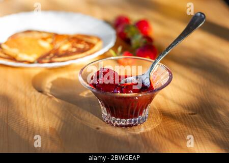 Marmellata di fragole e frittelle o frittelle fatte in casa. Idea di colazione sana. Messa a fuoco selettiva Foto Stock