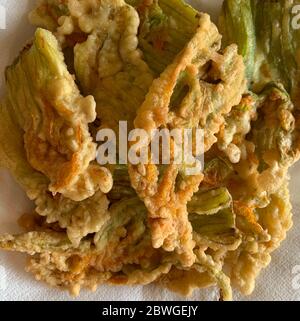 Fiori di zucchine fritti in pastella isolati su sfondo chiaro. Vista dall'alto. Concetto di verdure. Foto Stock