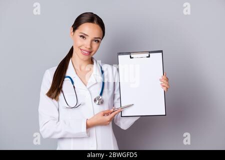 Foto di bella signora doc professionale che mostra il posto del paziente per la firma contratto contratto contratto contratto contratto contratto contratto contratto contratto contratto di assicurazione indossare stetoscopio bianco camice da laboratorio Foto Stock