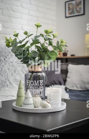 Decorazioni natalizie con candela sul tavolino da caffè in soggiorno vicino al divano closeup Foto Stock