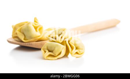 Tortellini su cucchiaio di legno. Pasta ripiena italiana isolata su sfondo bianco. Foto Stock