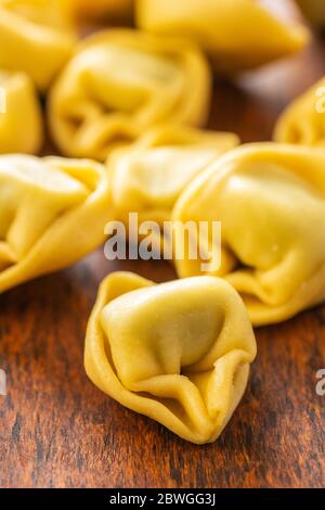 Tortellini. Pasta ripiena italiana su tavolo di legno. Foto Stock
