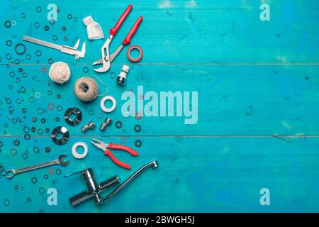 Set di utensili per tubazioni piatto posare vista dall'alto su sfondo di legno blu Foto Stock