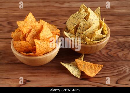 Tortilla scheggia il messicano e le patatine di tortilla dei nachos con i semi di chia in ciotole di bambù su un tavolo di legno. Primo piano Foto Stock