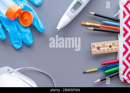 Disposizione di posa di un piano di ritorno a scuola con spazio di copia. Forniture scolastiche e attrezzature mediche necessarie per riaprire durante la pandemia COVID-19 Foto Stock