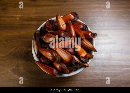 Ciotola di pinoli sul tavolo di legno. Vista dall'alto Foto Stock