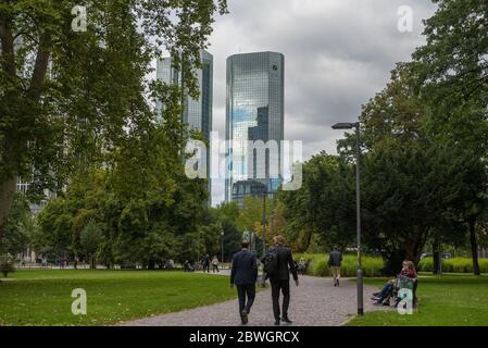 Persone non identificate nel Wall Park (Gallusanlage) di fronte allo skyline nel centro di Francoforte, Germania Foto Stock