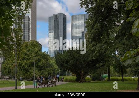 Persone non identificate nel Wall Park (Gallusanlage) di fronte allo skyline nel centro di Francoforte, Germania Foto Stock