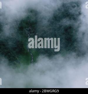 Una cascata coperta da nuvole intorno ad essa. Foto Stock