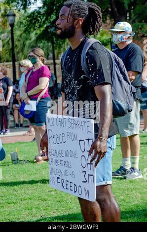 Un uomo ha un segno durante una veglia per George Floyd a Cathedral Square, 31 maggio 2020, a Mobile, Alabama. Foto Stock
