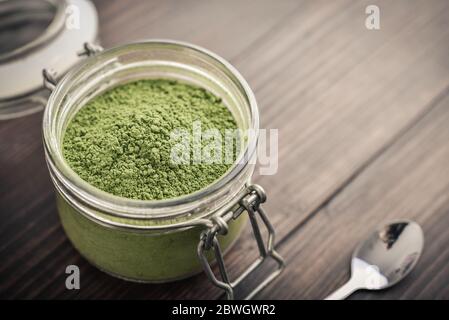 Polvere di Moringa in vaso di vetro su fondo di legno guardaroba Foto Stock