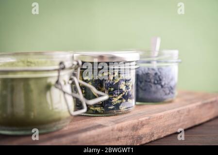 Polvere di tè Matcha, polvere di matcha blu e fiori secchi organici di piselli (tè di anchan) in vasi da closeup Foto Stock
