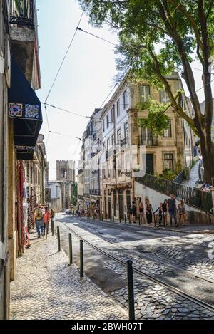 LISBONA, PORTOGALLO - 2 LUGLIO 2019: Linea del tram sulla zona collinare della città vecchia, Sao Tome strada nel distretto di Alfama è la parte del percorso turistico con nu Foto Stock