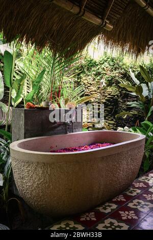 Vasca da bagno con petali di fiori - parte tradizionale di trattamento termale balinese Foto Stock