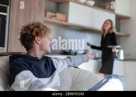 Chat di coppia in cucina come Donna prepara la colazione Foto Stock