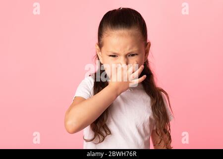 Scioccata ragazza che annodava qualcosa di stinoso in studio Foto Stock