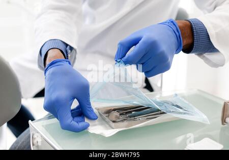 Dentista nero apertura mani set sigillato di utensili dentali Foto Stock