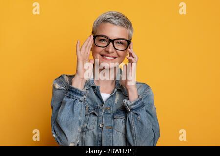 Concetto di vista e visione. Positivo bella donna matura che indossa nuovi occhiali eleganti Foto Stock