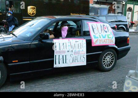 Un protestore alla marcia per George Floyd a New York il 5/30/2020, dopo in auto per fornire spuntini e acqua per le persone che marciano. Foto Stock