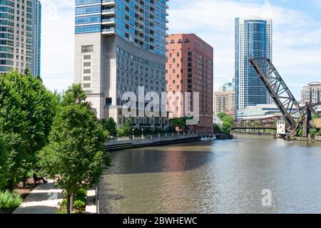 Il fiume Chicago e il lungofiume che guardano verso la sopraelevata Kinzie Street Railway Bridge con grattacieli Foto Stock